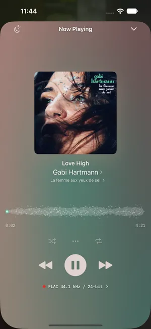 1-bit's Now Playing on iPhone — album art over a soft colour field, the track's waveform drawn behind the timeline, and a format badge reading FLAC 44.1 kHz / 24-bit